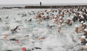 一斉に水しぶきを上げてスタートを切る選手ら＝２９日、天城町ヨナマビーチ