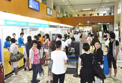 利用客で混雑するバニラ・エアの受付カウンター＝１０日正午前、奄美空港