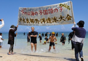 最後まで泳ぎ切り、笑顔でゴールする子どもたち＝２０日、和泊町のワンジョビーチ