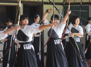 【弓道女子】集中力を高めて的を狙う与論中の仁禮日南子、市山日南子、重久麻琳の３選手（左から）＝２４日、鹿児島市の県武道館