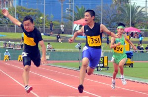 男子１年１００㍍を制した名瀬の勝（中央）＝２０日、県立鴨池陸上競技場 