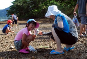 親子で干潟にメヒルギの苗を植えた＝１９日、龍郷町屋入