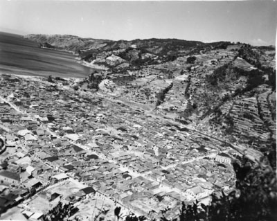 おがみ山から撮影したとみられる名瀬の街。裏書きには「米軍が来島、当時の名瀬市。Ｓ２１、２２年ごろ」。山の頂まで開墾されていた状況が分かる