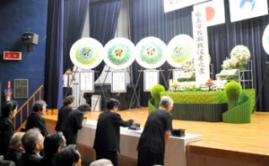 恒久平和への願いを込めて合掌する参列者ら＝１５日、奄美市名瀬公民館