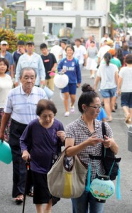 ちょうちんを掲げて祖先を送る人々＝１０日、奄美市名瀬の永田墓地