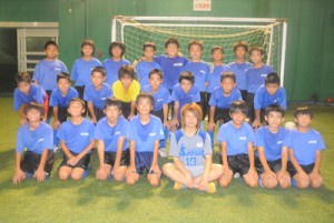 小学生時代に所属していたＦＣ朝日の練習に参加したＦＣ国際吉備大学シャルムの永野桃子さん（前列右から４人目）＝１８日、奄美市名瀬