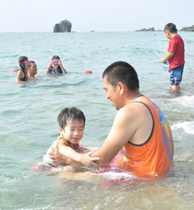 夏休み最終日を楽しむ親子連れ＝３１日、奄美市名瀬の大浜海浜公園