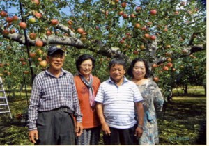 日本一周旅行の際、アルバイトしたリンゴ園に立ち寄った荒田さん（右から２人目）、スミ子夫人（右）と白戸さん夫妻＝８月２２日、弘前市