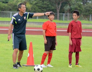 受講生に指示を送る島田コーチ（左）＝１３日、太陽が丘運動公園陸上競技場