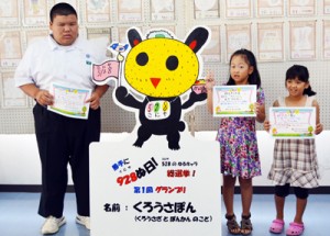 「古仁屋の日」のゆるキャラに選ばれた「くろうさぽん」と、考案者の勇晴己君＝２８日、瀬戸内町