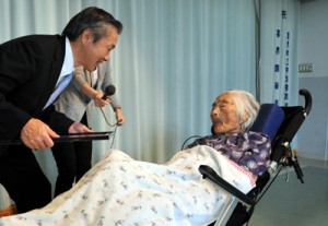 本支庁長から祝福の言葉をかけられる県内最高齢の田島ナビさん＝１１日、喜界町