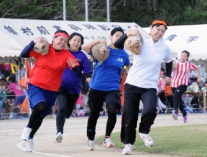 女性も力強い走りを見せた重量運搬リレー＝１９日、知名町総合グラウンド