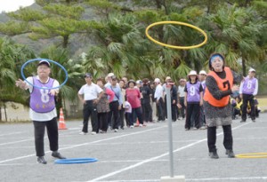 ポール目掛けてフープを投げる選手たち＝９日、龍郷町補助グラウンド