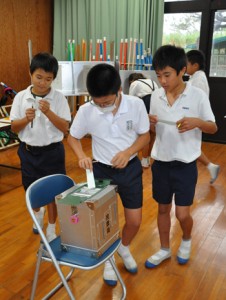 模擬投票で意中の候補に１票を投じた児童ら＝２１日、徳之島町の神之嶺小学校