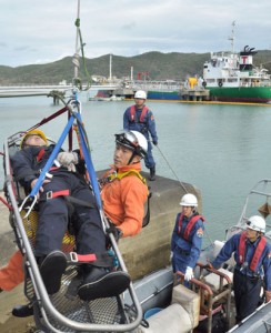 タンカー（奥）からの油流出を想定、海中からの負傷者救出などを行った訓練＝２５日、龍郷町