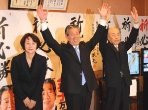 ２回目の当選を決め、万歳する金子万寿夫氏（中央）＝１４日午後８時１０分すぎ、鹿児島市谷山中央１丁目