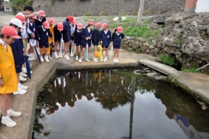 学校近くの湧き水を見学する児童ら＝８日、知名町屋者