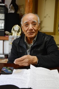 遺品を前に兄の思い出を語る久保末正さん＝奄美市名瀬小宿