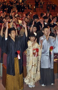 万歳を三唱して晴れの門出を祝う新成人＝３日、龍郷町りゅうゆう館