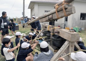 さたぐるまを使ってサトウキビを搾る子どもたち＝２８日、和泊町の国頭小