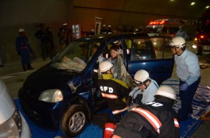 訓練で事故車両のドアをこじ開けて負傷者を救出する消防隊員ら＝２４日、瀬戸内町の網野子トンネル