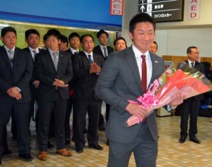 歓迎の花束を受け取るパナソニック野球部の松元主将＝２日、奄美空港