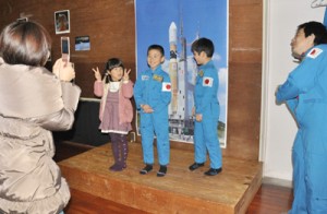 宇宙飛行士の訓練着を試着する参加者＝１１日、奄美少年自然の家