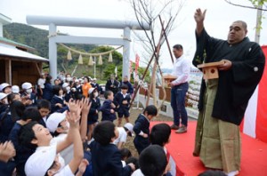 子どもたちに豆をまく武蔵川親方と三崎さん＝３日、瀬戸内町