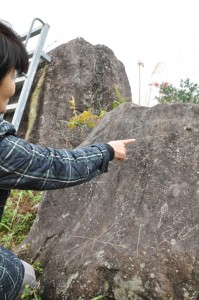 いたずら書きが見つかった母間線刻画史跡敷地内の石＝５日、徳之島町