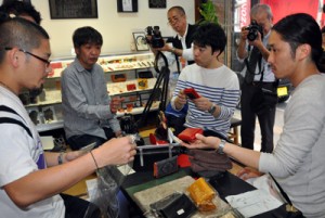 大島紬を使った小物を見せて助言を受ける川畑さん（左）＝１９日、奄美市名瀬