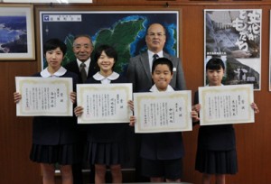 賞状を手に笑顔を見せる子どもたち＝１０日、龍郷町役場