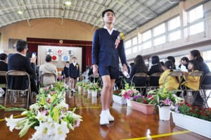 多くの花で彩られた式場を後にする卒業生＝２４日、知名町の住吉小学校体育館