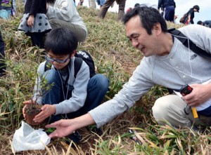 ウオーキングで汗を流した後、タイワンヤマツツジの苗木を植樹する参加者＝８日、大和村の宮古崎