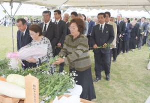 ３７３７柱の冥福を祈り、献花する参列者たち＝７日、伊仙町犬田布岬