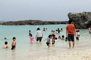 水水遊びを楽しむ親子連れなどでにぎわった海開き行事＝２６日、喜界町スギラビーチ