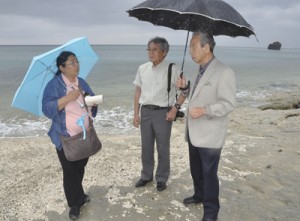 砂が激減し、ビーチロックがむきだしになった海岸の状況を調べる向井代表（中央）と安部さん（左）＝２８日、奄美市の大浜海浜公園