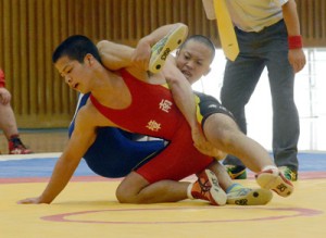 ６０㌔級、決勝進出を懸けた２回戦で岩佐那由汰（鹿屋中央）の攻めを耐える武田海喜（樟南）＝２０日、樟南高校