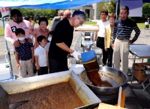 黒砂糖の製造工程を珍しそうに見入る市民ら（上）と、六調などでにぎわった「島唄の饗宴」＝１日、鹿児島市山下町