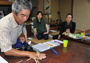 竹を使った手遊びを教える竹さん（左）＝２８日、与論町古里