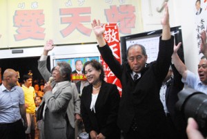 家族や支持者と共に万歳三唱し、初当選を喜ぶ鎌田氏（右）＝１４日午後９時４５分、瀬戸内町古仁屋の選挙事務所