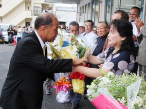 初登庁で職員から花束を受け取る鎌田愛人町長＝２５日、瀬戸内町役場