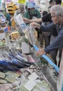 トカラ列島の特産品を品定めする買い物客ら＝６日、奄美市名瀬