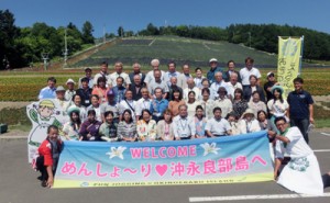 花畑の前で記念撮影する和泊町の訪問団＝６日、北海道・中富良野町（和泊町役場提供）