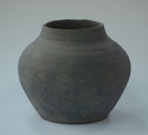 奄美市博物館に寄贈されたカムィヤキ壺形陶器と寄贈した吉村裕一さん（写真左、いずれも提供写真）