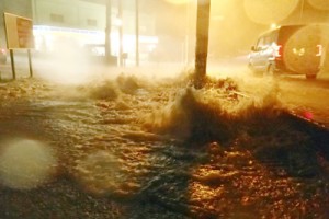 記録的な大雨で各地で道路が冠水。側溝から水が噴き出す県道＝２５日午後８時２０分ごろ、徳之島町亀津