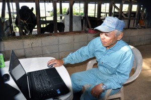 パソコンでネットワークカメラの状態を確認する上野さん＝７月２８日、与論町那間