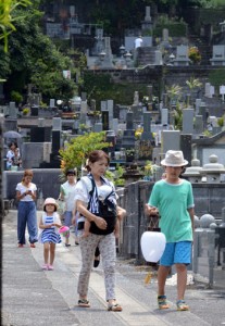 ちょうちんを手に先祖の霊を自宅へと導く人々＝２６日、奄美市名瀬の永田墓地