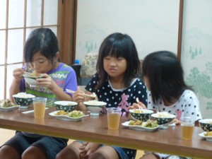 戦中戦後の食事を体験する児童ら＝１５日、喜界町中央公民館（提供写真）