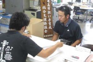 漁業担い手育成支援事業を申請する石山さん（奥）＝１３日、奄美市役所（提供写真）