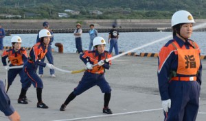 気合の入った表情で放水訓練する女性隊員＝５日、和泊町